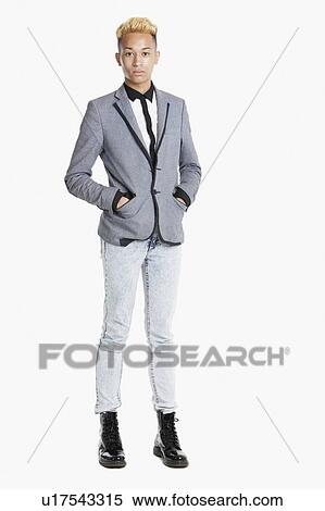 Stock Photography - Portrait of a teenage boy standing in smart casuals over gray background. Fotosearch