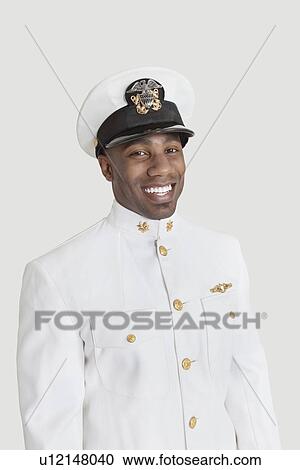 Stock Image - Portrait of a young African American US Navy officer smiling over gray background. Fotosearch