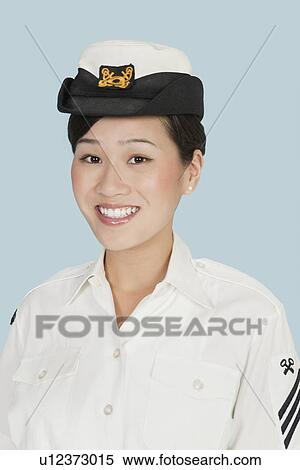 Stock Photography - Portrait of a young beautiful US Navy officer smiling over light blue background. Fotosearch