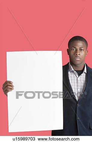 Portrait of a young man holding blank cardboard over pink background View Large Photo Image Stock Image - Portrait of a young man holding blank cardboard over pink background. Fotosearch
