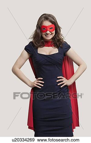 Stock Photo - Portrait of a young woman in superhero costume over gray background. Fotosearch