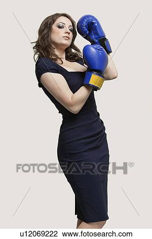 Portrait of a young woman wearing blue boxing gloves against gray background View Large Photo Image Stock Image - Portrait of a young woman wearing blue boxing gloves against gray background. Fotosearch