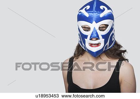 Portrait of a young woman wearing wrestling mask over gray background View Large Photo Image Stock Image - Portrait of a young woman wearing wrestling mask over gray background. Fotosearch
