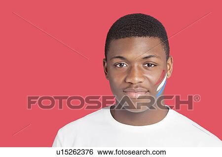 Stock Photograph - Portrait of an African American man with Dutch flag on his face over red background. Fotosearch