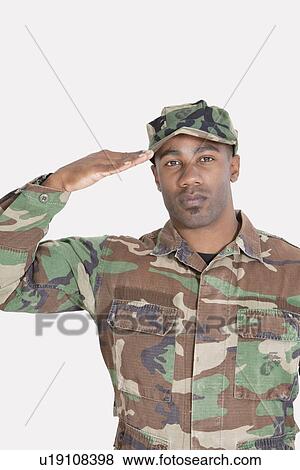 Stock Photo - Portrait of an African American US Marine Corps soldier saluting over gray background. Fotosearch