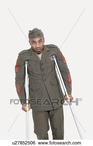 Portrait of an African American US military officer with crutches over gray background View Large Photo Image Stock Photograph - Portrait of an African American US military officer with crutches over gray background. Fotosearch