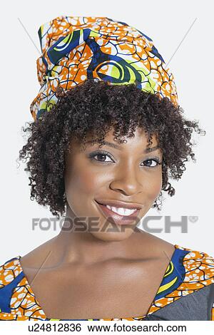 Stock Photograph - Portrait of an African American woman smiling over gray background. Fotosearch