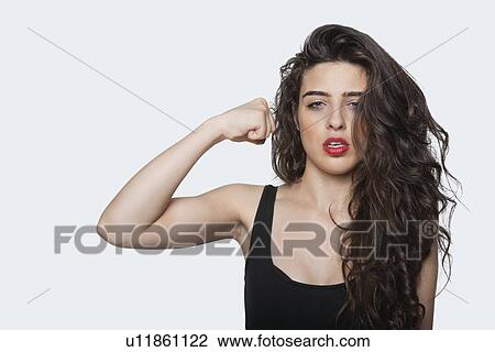 Portrait of an aggressive woman with punching gesture over gray background View Large Photo Image Stock Image - Portrait of an aggressive woman with punching gesture over gray background. Fotosearch