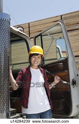 Portrait of an Asian female industrial worker standing by vehicle door View Large Photo Image Stock Photo - Portrait of an Asian female industrial worker standing by vehicle door. Fotosearch