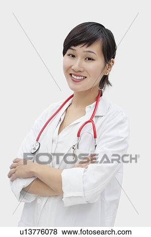 Portrait of an Asian female veterinarian standing arms crossed over gray background View Large Photo Image Stock Photo - Portrait of an Asian female veterinarian standing arms crossed over gray background. Fotosearch