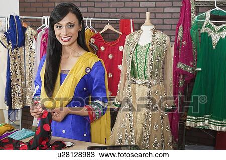 Portrait of an attractive female dressmaker working on a cloth View Large Photo Image Stock Image - Portrait of an attractive female dressmaker working on a cloth. Fotosearch