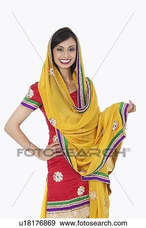 Stock Photo - Portrait of an attractive Indian female in traditional wear standing over white background. Fotosearch