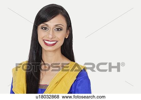 Stock Photo - Portrait of an attractive Indian woman in traditional wear smiling against gray background. Fotosearch
