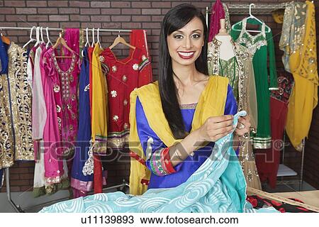 Portrait of an Indian female dressmaker working at design studio View Large Photo Image Stock Image - Portrait of an Indian female dressmaker working at design studio. Fotosearch