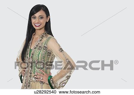 Portrait of an Indian woman in elegant designer wear standing with hands on hips over gray background View Large Photo Image Stock Image - Portrait of an Indian woman in elegant designer wear standing with hands on hips over gray background. Fotosearch