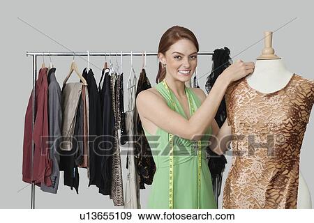 Portrait of beautiful female fashion designer adjusting cloth on tailor's dummy View Large Photo Image Stock Photo - Portrait of beautiful female fashion designer adjusting cloth on tailor's dummy. Fotosearch
