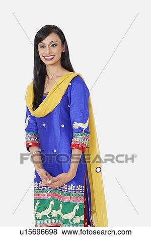 Portrait of beautiful Indian female traditional wear standing against gray background View Large Photo Image Stock Photo - Portrait of beautiful Indian female traditional wear standing against gray background. Fotosearch