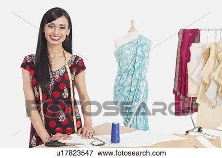 Portrait of beautiful Indian female tailor smiling View Large Photo Image Stock Photo - Portrait of beautiful Indian female tailor smiling. Fotosearch