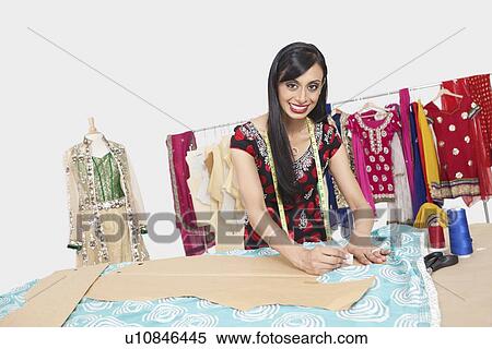 Stock Photography - Portrait of beautiful Indian female fashion designer working. Fotosearch