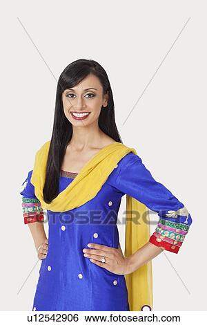 Portrait of beautiful Indian woman in traditional wear standing with hands on hips over gray background View Large Photo Image Stock Photograph - Portrait of beautiful Indian woman in traditional wear standing with hands on hips over gray background. Fotosearch