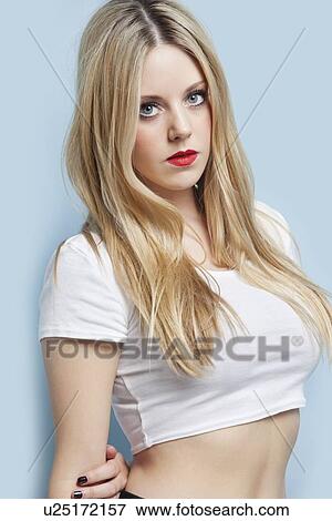 Stock Photo - Portrait of beautiful young blond woman with red lips over light blue background. Fotosearch