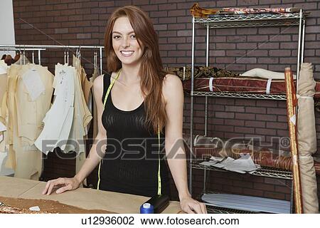 Portrait of beautiful young female dressmaker smiling View Large Photo Image Stock Image - Portrait of beautiful young female dressmaker smiling. Fotosearch
