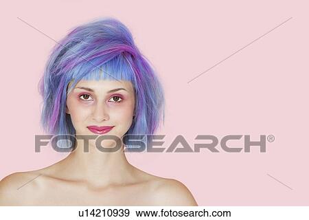 Stock Photo - Portrait of beautiful young woman with dyed hair against pink background. Fotosearch