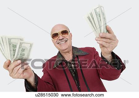 Portrait of cheerful senior man showing US banknotes against gray background View Large Photo Image Stock Image - Portrait of cheerful senior man showing US banknotes against gray background. Fotosearch