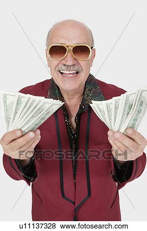Portrait of cheerful senior man with US banknotes against gray background View Large Photo Image Stock Photo - Portrait of cheerful senior man with US banknotes against gray background. Fotosearch