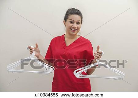 Portrait of female housekeeper holding white plastic hangers against gray background View Large Photo Image Stock Photography - Portrait of female housekeeper holding white plastic hangers against gray background. Fotosearch