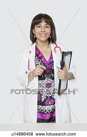 Portrait of female veterinarian holding folder against gray background View Large Photo Image Stock Photo - Portrait of female veterinarian holding folder against gray background. Fotosearch