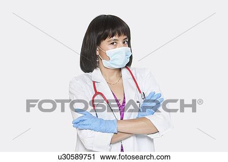 Portrait of female veterinarian standing arms crossed over gray background View Large Photo Image Stock Image - Portrait of female veterinarian standing arms crossed over gray background. Fotosearch