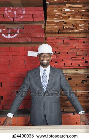 Portrait of happy African American male contractor with stacked wooden planks in background View Large Photo Image Stock Photography - Portrait of happy African American male contractor with stacked wooden planks in background. Fotosearch