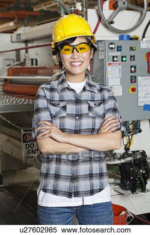 Portrait of happy Asian female industrial worker with machinery in background View Large Photo Image Stock Photography - Portrait of happy Asian female industrial worker with machinery in background. Fotosearch