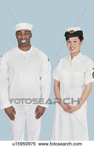 Portrait of happy female US Navy officer with male sailor over light blue background View Large Photo Image Stock Photography - Portrait of happy female US Navy officer with male sailor over light blue background. Fotosearch