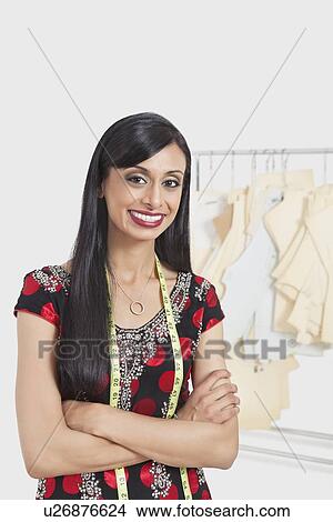 Portrait of happy Indian female tailor standing arms crossed View Large Photo Image Picture - Portrait of happy Indian female tailor standing arms crossed. Fotosearch