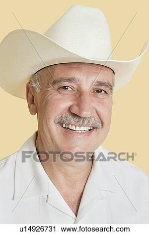 Portrait of happy senior man wearing cowboy hat over yellow background View Large Photo Image Stock Image - Portrait of happy senior man wearing cowboy hat over yellow background. Fotosearch