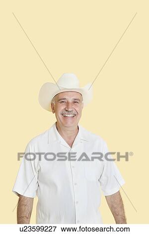 Portrait of happy senior man wearing cowboy hat over yellow background View Large Photo Image Stock Photo - Portrait of happy senior man wearing cowboy hat over yellow background. Fotosearch