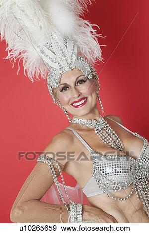Portrait of happy senior showgirl with feather headpiece over red colored background View Large Photo Image Stock Photo - Portrait of happy senior showgirl with feather headpiece over red colored background. Fotosearch