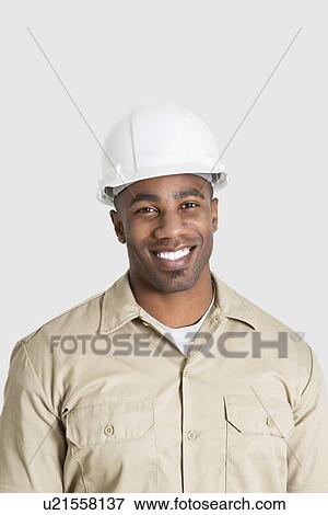 Portrait of happy young African male construction worker over gray background View Large Photo Image Stock Photo - Portrait of happy young African male construction worker over gray background. Fotosearch