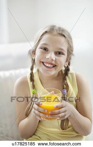 Portrait of happy young girl drinking orange juice View Large Photo Image Stock Photography - Portrait of happy young girl drinking orange juice. Fotosearch