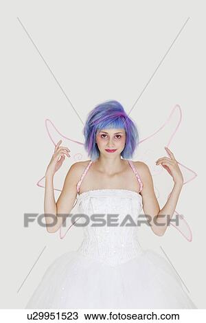 Portrait of happy young woman dressed as angel with dyed hair against gray background View Large Photo Image Stock Image - Portrait of happy young woman dressed as angel with dyed hair against gray background. Fotosearch