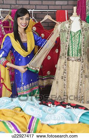 Portrait of Indian designer measuring traditional outfit at design studio View Large Photo Image Stock Photo - Portrait of Indian designer measuring traditional outfit at design studio. Fotosearch