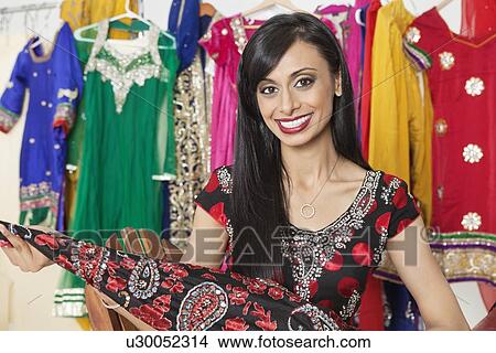 Portrait of Indian dressmaker holding a cloth View Large Photo Image Picture - Portrait of Indian dressmaker holding a cloth. Fotosearch