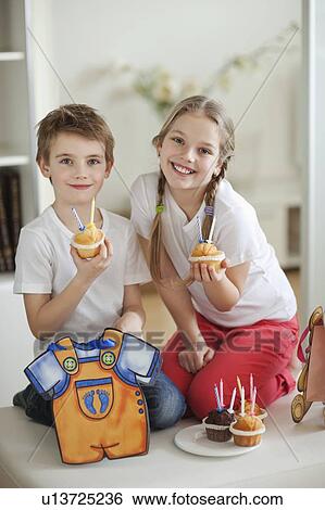 Portrait of little boy and girl with cup cakes View Large Photo Image Stock Photograph - Portrait of little boy and girl with cup cakes. Fotosearch