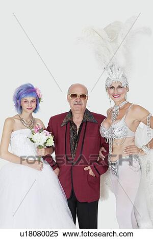 Portrait of man standing arms in arms with senior showgirl and daughter in wedding dress over gray background View Large Photo Image Stock Photography - Portrait of man standing arms in arms with senior showgirl and daughter in wedding dress over gray background. Fotosearch