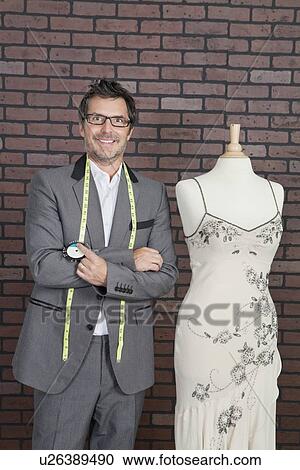 Portrait of mature male fashion designer standing next to tailor's dummy View Large Photo Image Stock Image - Portrait of mature male fashion designer standing next to tailor's dummy. Fotosearch