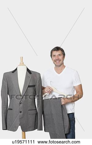 Portrait of mature man standing next to tailor's dummy over gray background View Large Photo Image Stock Image - Portrait of mature man standing next to tailor's dummy over gray background. Fotosearch