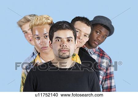 Stock Image - Portrait of multi-ethnic friends standing in line over blue background. Fotosearch