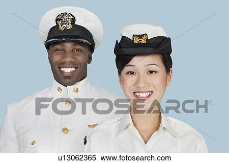 Stock Photography - Portrait of multi-ethnic US Navy officers smiling over light blue background. Fotosearch